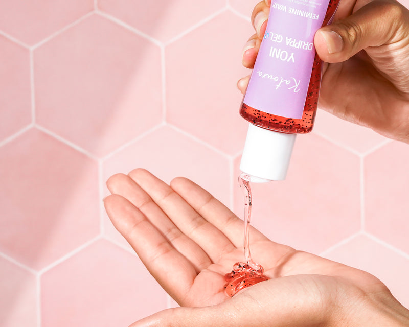 Serum being dispensed from a bottle into a hand against a hexagonal-patterned background.